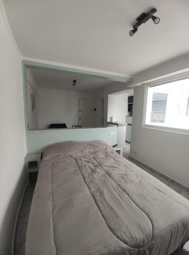 Cette chambre blanche dispose d'un grand lit et d'une fenêtre. dans l'établissement Dpto Falucho8 plaza Colón 2 personas, à Mar del Plata