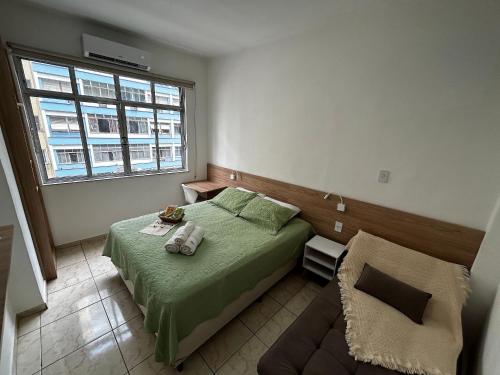 Un dormitorio con una cama verde y una ventana en Studio 516 Copacabana Av Atlântica, Posto 6, en Río de Janeiro