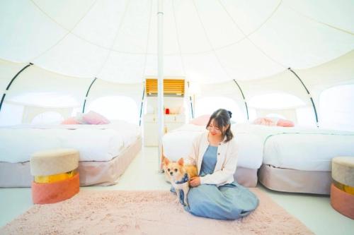 a woman sitting on the floor with a dog in a tent at Kanonji City - Camp - Vacation STAY 42265v in Kanonji