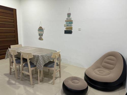 einen Esstisch und Stühle mit einem Tisch und einem Stuhl in der Unterkunft Roxy homestay in Alor Setar
