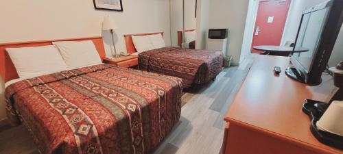 Habitación de hotel con 2 camas y TV en Ace Inn en Fort McMurray