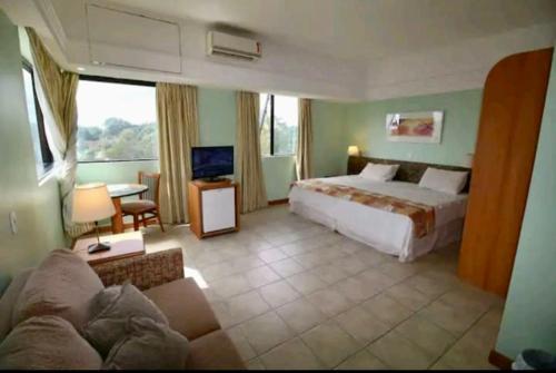 ein Hotelzimmer mit einem Bett und einem Sofa in der Unterkunft Tropical Executive Hotel APT 606 in Manaus