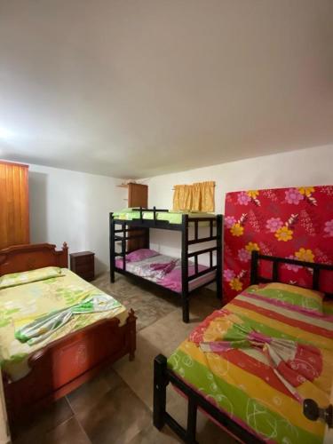 サンタ・マルタにあるHERMOSA CASA CAMPESTRE EN SANTA MARTAのベッド2台と二段ベッド1組が備わる客室です。
