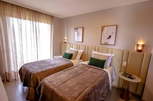 um quarto de hotel com duas camas e uma janela em Casa 19 da Vila Beija Flor em Mucugê