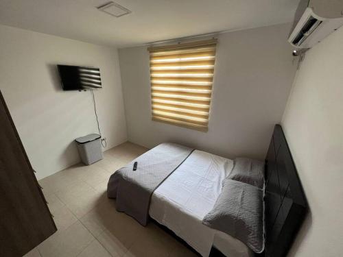 ein kleines Schlafzimmer mit einem Bett und einem Fenster in der Unterkunft Casa con piscina Punta Carnero in Salinas