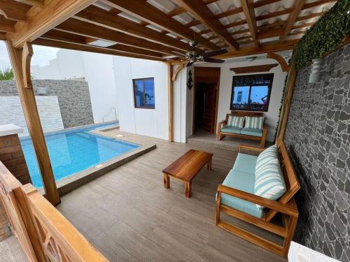 une terrasse avec une piscine, une table et des chaises dans l'établissement Casa con piscina Punta Carnero, à Salinas
