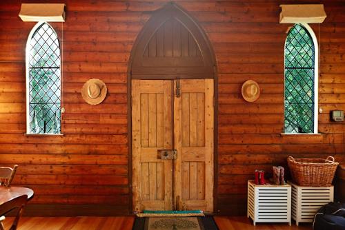 une maison en bois avec une porte et deux fenêtres dans l'établissement Blue Gum Church - Artistic Retreat, à Beechworth