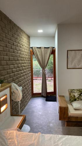 ein Wohnzimmer mit einem Fenster mit einem Sofa und einem Tisch in der Unterkunft CASA RAÍZ RÍO ANCHO in Mingueo