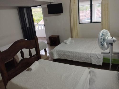 a hotel room with two beds and a fan at HOTEL VILLA CAMPESTRE AVENTUREROS in San Gil