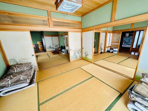 einen Blick über ein Wohnzimmer mit einem Bett und einem Spiegel in der Unterkunft 青森伝統芸能を楽しめる繭子の宿 in Hachinohe