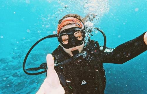 Dive and Trek Resort and Marine Sanctuary في Bauan: شخص في الماء يمسك الحبل