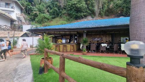 a fence in front of a building with a restaurant at Dive and Trek Resort and Marine Sanctuary in Bauan