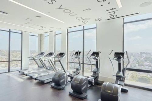 a gym with rows of tread machines and windows at Stunning 1bed Apartment Downtown 1 min to Petco Park Convention Center in San Diego