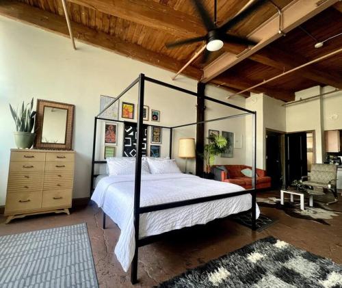 a bedroom with a bed and a dresser and a ceiling at 420 Friendly Downtown Loft KING suite FREE parking in Detroit