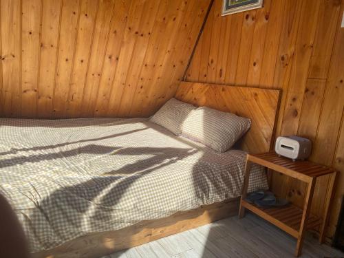 Cama en habitación con pared de madera en Nhà của Nếp en Plei Brel (2)