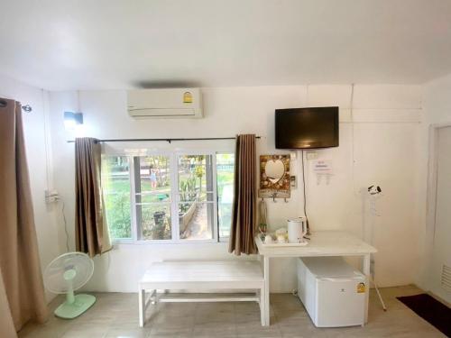 una camera con un tavolo bianco e una finestra di Sleep Home Khaoyai a Pak Chong