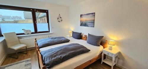 a bedroom with two twin beds and a window at Seesternchen-FeWo-Nr-1-EG in Böhl