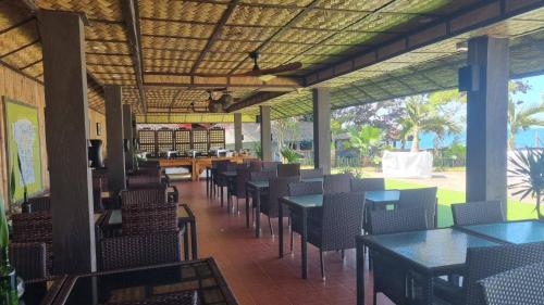 a dining room with tables and chairs in a restaurant at Dive and Trek Resort and Marine Sanctuary in Bauan