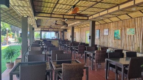 a dining room with tables and chairs in a building at Dive and Trek Resort and Marine Sanctuary in Bauan