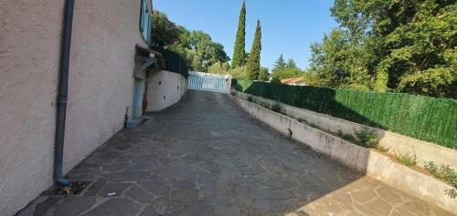 a walkway next to a fence next to a building at Les loriots in Les Adrets de l'Esterel