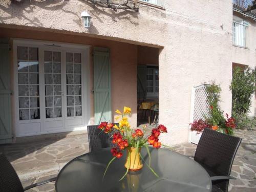 a glass table with a vase of flowers on it at Les loriots in Les Adrets de l'Esterel