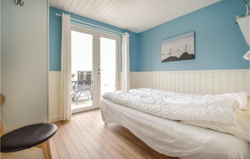 1 dormitorio con paredes azules, 1 cama y 1 silla en Rnnebo, en Nyborg
