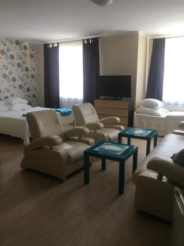 a hotel room with couches and a bed and a tv at PATIO dom gościnny in Łukęcin