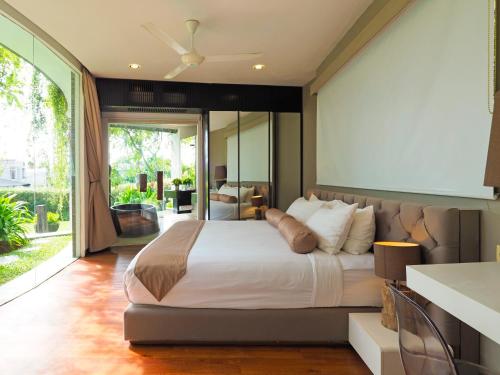 ein Schlafzimmer mit einem großen Bett und einem großen Fenster in der Unterkunft Villa Toraja by LifestyleRetreats in Canggu