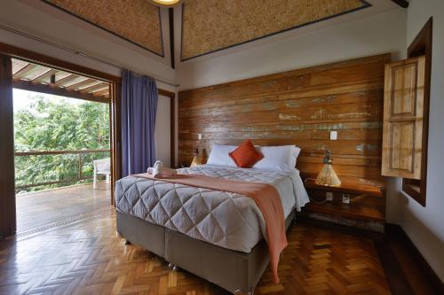 sypialnia z łóżkiem i drewnianą ścianą w obiekcie Cliffside Boutique Hotel w mieście Búzios