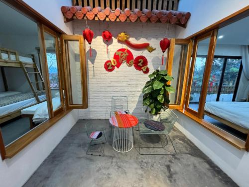 a room with a table and chairs and windows at En nho Homestay SaPa in Sa Pa