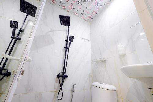 een badkamer met een douche, een toilet en een wastafel bij Urbanview Hotel Kota Tua Jakarta in Jakarta