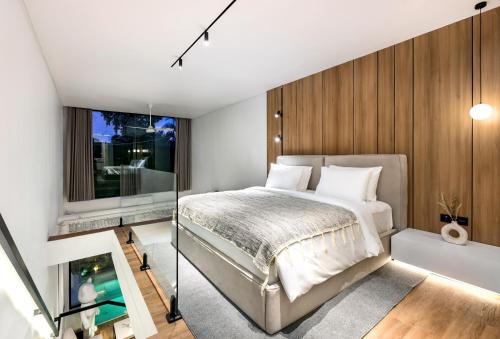 ein Schlafzimmer mit einem Bett und einer Glaswand in der Unterkunft Alex Villas Complex N3 in Canggu