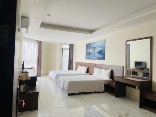 Habitación de hotel con cama y espejo en MARINA Bình Dương, en Ấp Phú Thọ