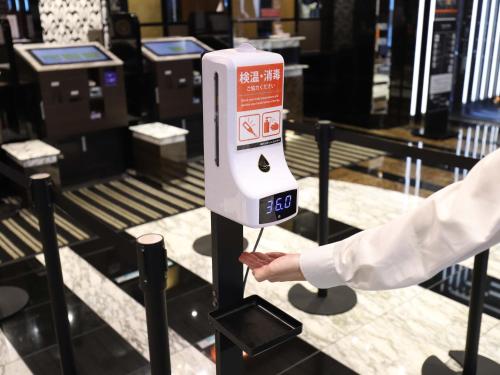a person is holding up a pay meter in a store at APA Hotel Osaka Kadomashi Ekimae in Kadoma