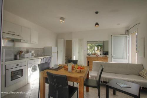 une cuisine et un salon avec une table et un canapé dans l'établissement Idéal logement Cargese 4, à Cargèse