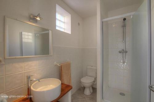 une salle de bain blanche avec un lavabo et des toilettes dans l'établissement Idéal logement Cargese 4, à Cargèse