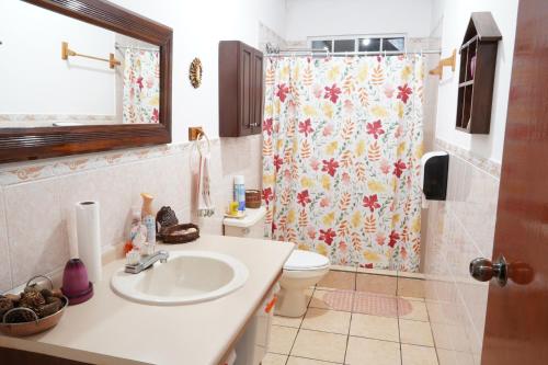 ein Bad mit einem Waschbecken und einem Duschvorhang in der Unterkunft El paraíso de Apaneca in Apaneca