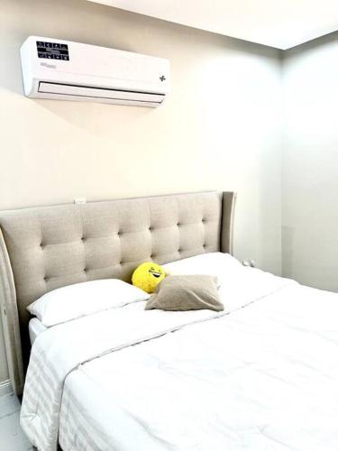 um quarto com uma cama branca e uma almofada em Brand new apartment em Al Fayşalīyah