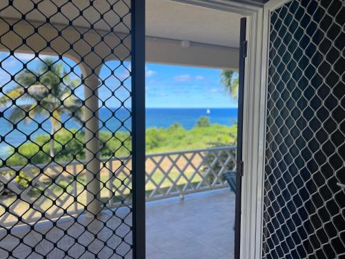 a screened in porch with a view of the ocean at ‘MAYARO’ Private Room with Ocean View in Saint Philip