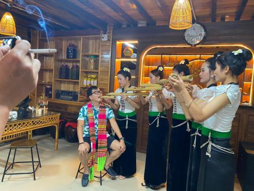 eine Gruppe von Menschen, die in einem Zimmer Musik spielen in der Unterkunft Nậm Thia Homestay in Yên Bái