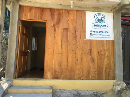 a building with a wooden door with a sign on it at AmyRooms in El Remate