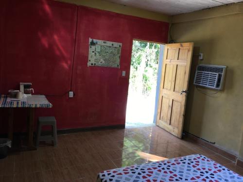 a room with a red wall and a door at AmyRooms in El Remate