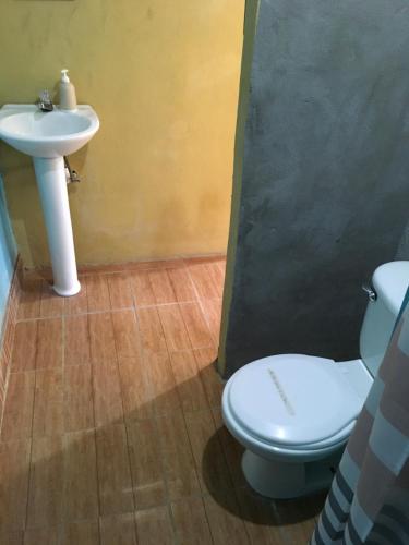 La salle de bains est pourvue d'un lavabo et de toilettes. dans l'établissement AmyRooms, à El Remate