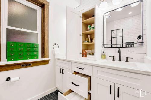 a bathroom with a sink and a mirror at The Twin Lions: Bespoke Travel Lodge w/ Speakeasy* in Chicago