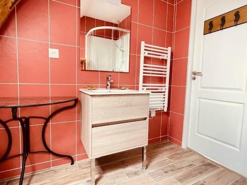 un bagno rosso con lavandino e specchio di Gîte familial de charme avec jardin, proche de sentiers et activités nature, tout inclus ! - FR-1-510-187 a Wallers