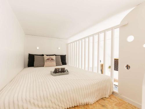 a white bedroom with a large bed with white walls at Studio Bourisp, 1 pièce, 4 personnes - FR-1-296-495 in Bourisp