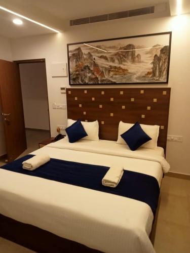 a bedroom with a large bed with blue pillows at Hotel Sea side in Calangute