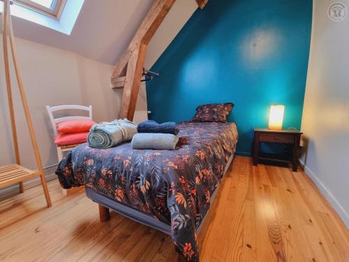 une chambre avec un lit et un mur bleu dans l'établissement Appartement tout équipé dans un cadre naturel, proche du Parc Avesnois et commodités, jusqu'à 5 pers. - FR-1-510-189, à Orsinval