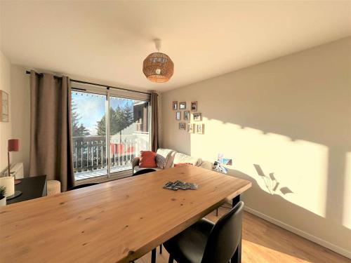 une salle à manger avec une table en bois et une grande fenêtre dans l'établissement Studio fonctionnel 3 couchages, balcon, proche pistes et commodités - Serre Chevalier Vallée - FR-1-330F-235, à La Salle Les Alpes