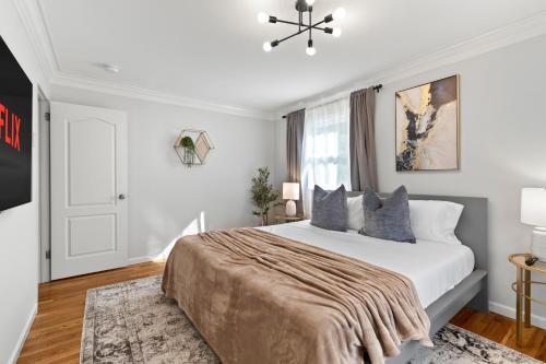 a white bedroom with a large bed and a window at New Beach Home near Stamford Downtown/Shippan in Stamford